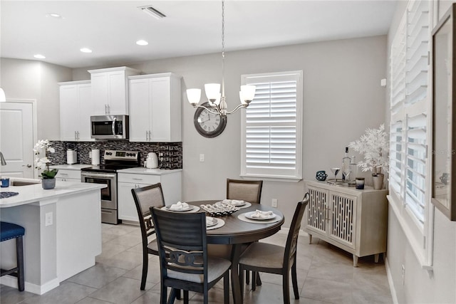 dining area featuring a chandelier, light tile patterned floors, plenty of natural light, and sink