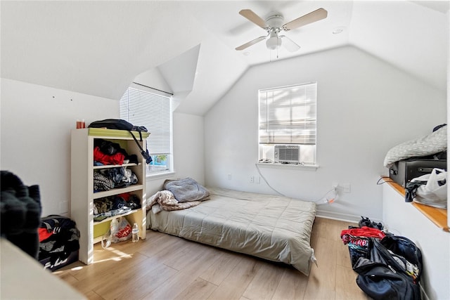 bedroom with multiple windows, ceiling fan, wood-type flooring, and lofted ceiling