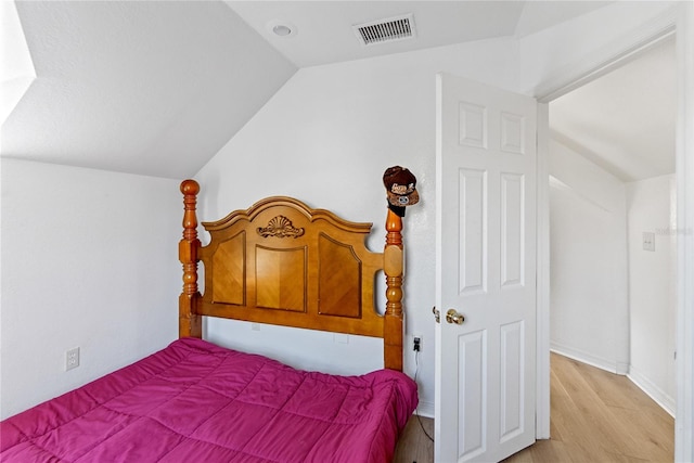 bedroom featuring light hardwood / wood-style flooring and vaulted ceiling