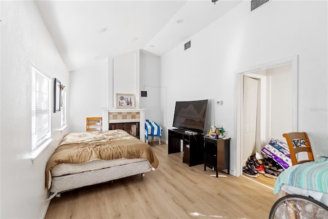 bedroom with light wood-type flooring and vaulted ceiling