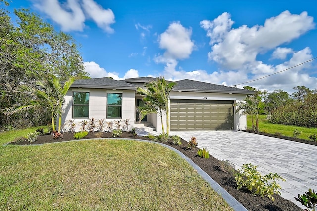 view of front of home with a front yard and a garage