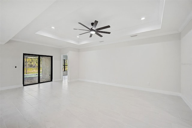 unfurnished room with a tray ceiling, ceiling fan, and ornamental molding