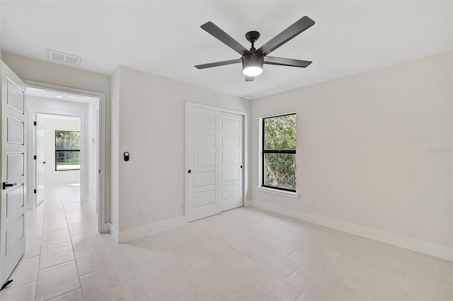 unfurnished bedroom featuring light tile patterned floors, a closet, and ceiling fan