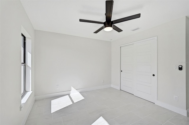 unfurnished bedroom featuring ceiling fan, light tile patterned floors, and a closet