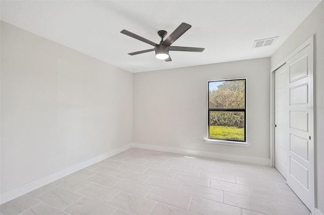 tiled empty room featuring ceiling fan