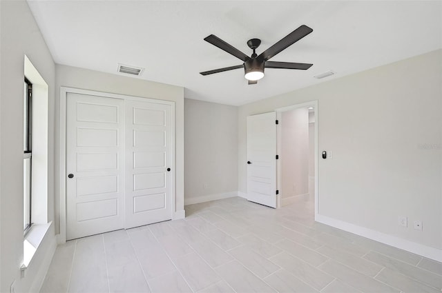 unfurnished bedroom featuring ceiling fan and a closet