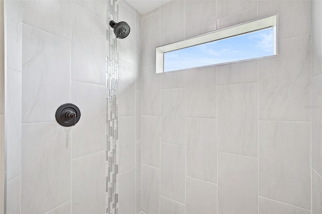 bathroom with a healthy amount of sunlight and tiled shower