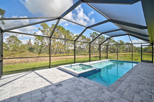 view of swimming pool featuring glass enclosure, an in ground hot tub, and a patio