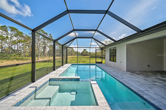 view of pool with a lawn, glass enclosure, an in ground hot tub, and a patio area