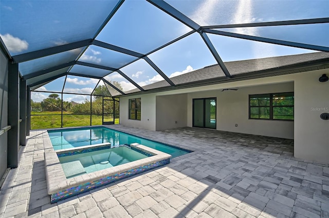 view of pool featuring an in ground hot tub, glass enclosure, and a patio area