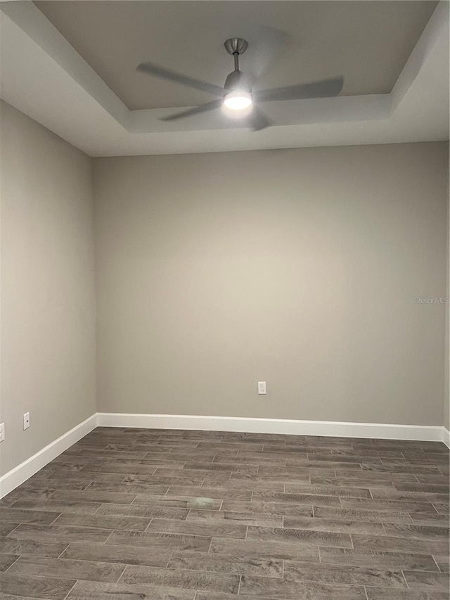 unfurnished room with a raised ceiling and ceiling fan