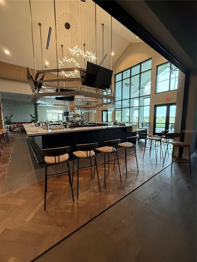 bar featuring a high ceiling, parquet floors, and pendant lighting