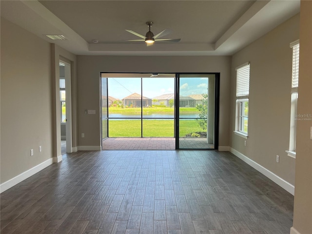 spare room with ceiling fan and a raised ceiling