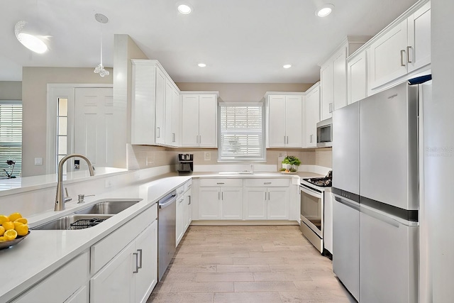 kitchen featuring sink, white cabinets, plenty of natural light, and appliances with stainless steel finishes