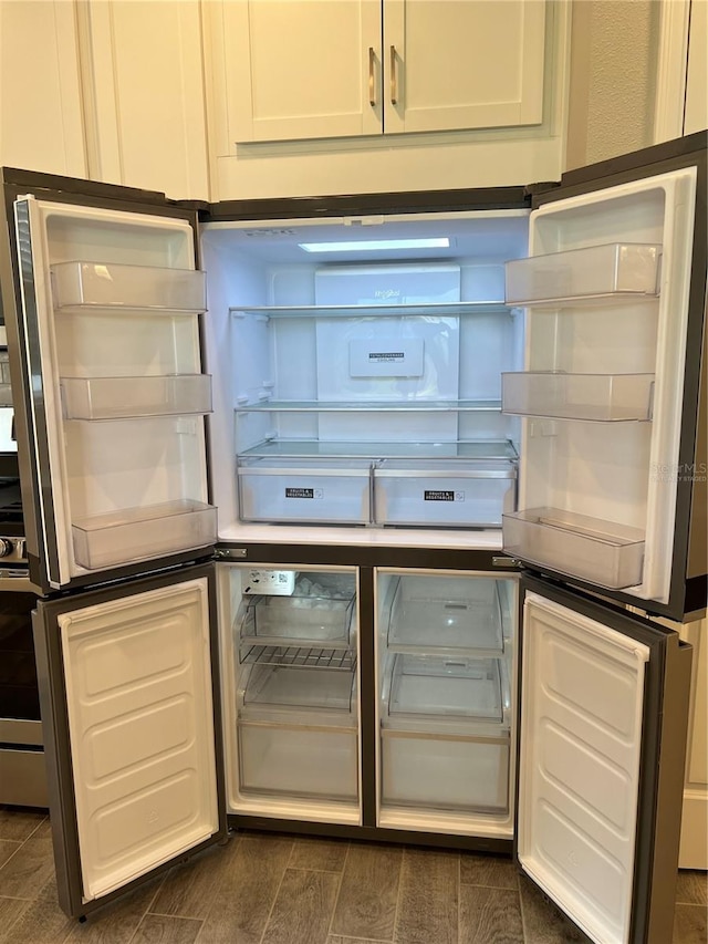 kitchen with white cabinets, range with gas cooktop, and fridge