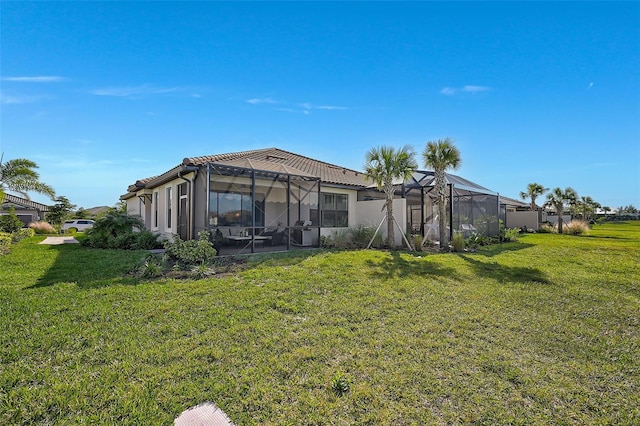 back of property featuring a yard and glass enclosure