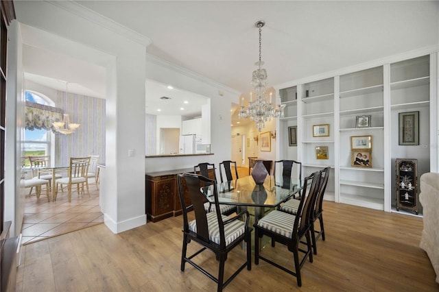 dining area featuring ornamental molding, a chandelier, and light wood-type flooring