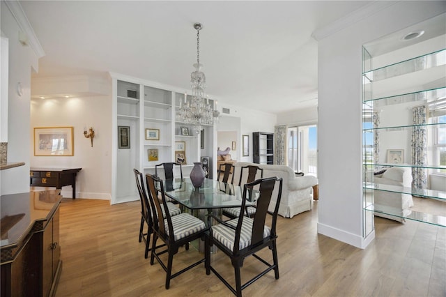 dining room featuring light hardwood / wood-style flooring, ornamental molding, and a notable chandelier