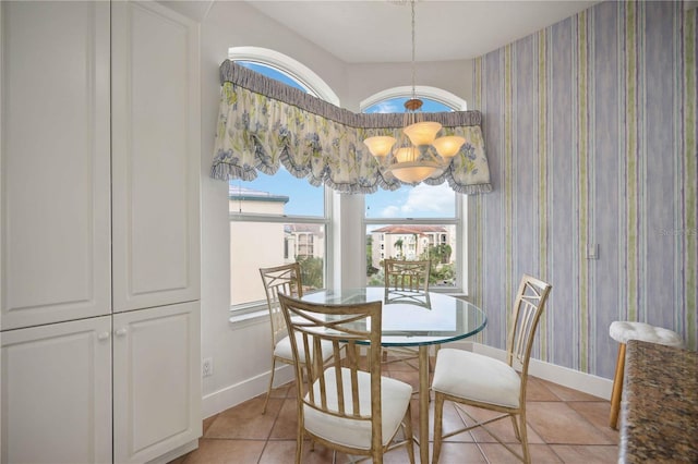 tiled dining room featuring a wealth of natural light and an inviting chandelier