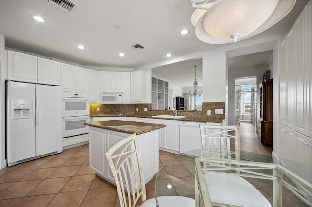 kitchen with backsplash, kitchen peninsula, sink, and white appliances