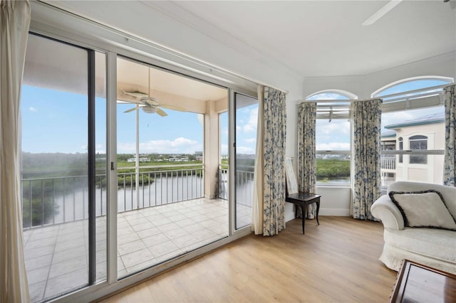 interior space with ceiling fan, a healthy amount of sunlight, and a water view