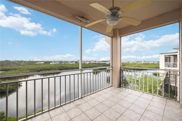 unfurnished sunroom with a water view and ceiling fan