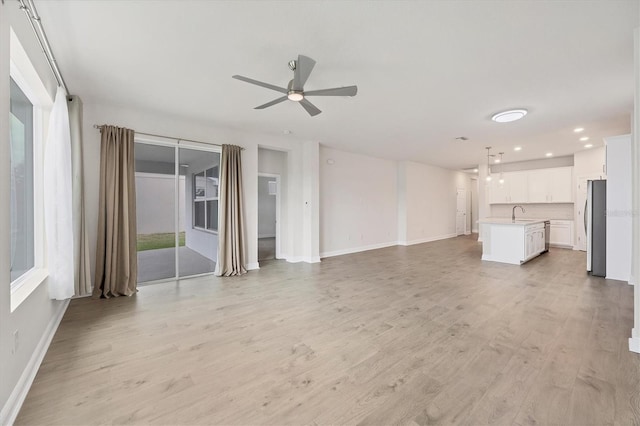 unfurnished living room with ceiling fan and light hardwood / wood-style flooring