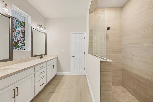 bathroom with a tile shower and vanity