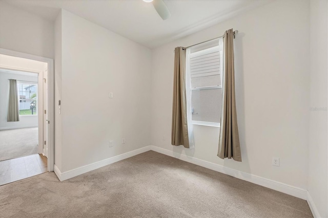 carpeted spare room with ceiling fan