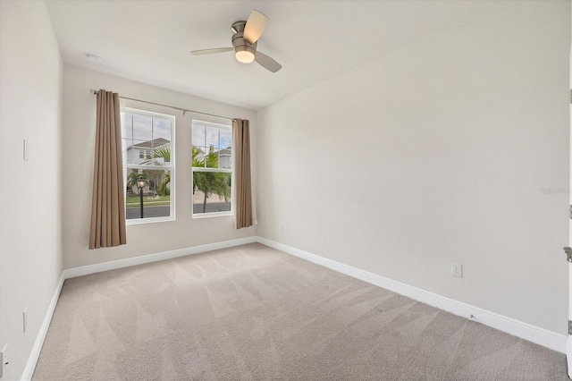 carpeted spare room featuring ceiling fan