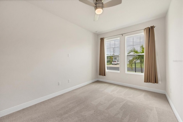 spare room with ceiling fan and light colored carpet