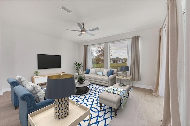 living room with light hardwood / wood-style flooring and ceiling fan