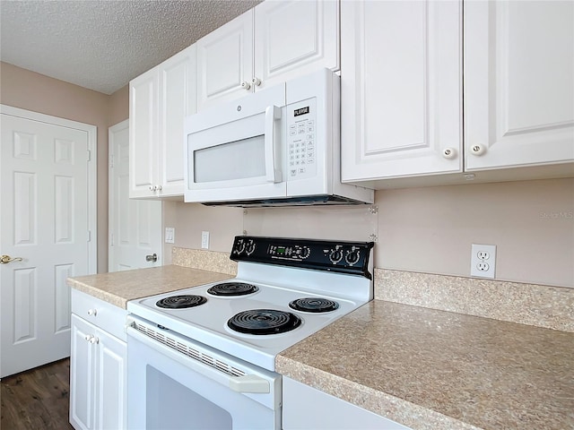 kitchen featuring dark hardwood / wood-style floors, a textured ceiling, white cabinets, and white appliances