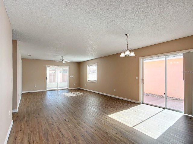 unfurnished room with hardwood / wood-style flooring, ceiling fan with notable chandelier, and a textured ceiling