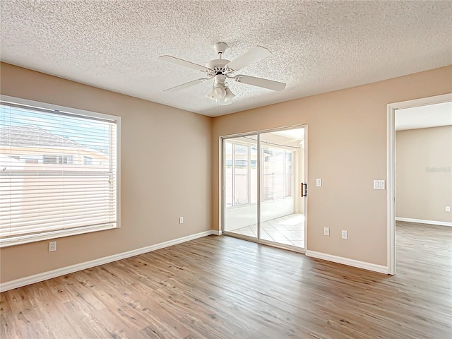 empty room featuring wood-type flooring, ceiling fan, and a textured ceiling