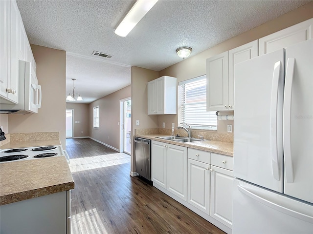 kitchen with decorative light fixtures, dishwasher, white fridge, and white cabinets