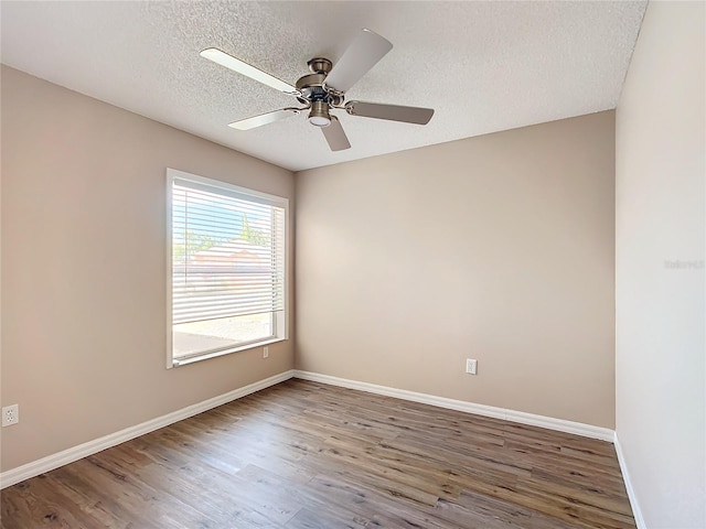 spare room featuring ceiling fan, dark hardwood / wood-style floors, and a textured ceiling