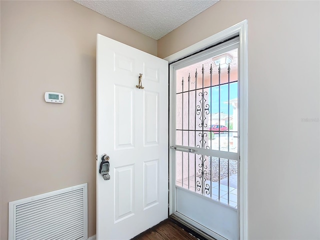 entryway with dark hardwood / wood-style flooring and a textured ceiling