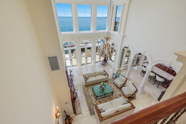 309 Ringling Point Dr, Sarasota, FL 34234 - living area with ornate columns, a water view, a high ceiling, and a chandelier