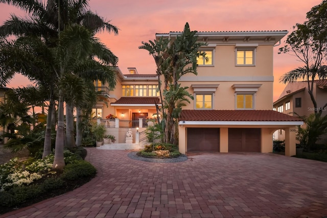 309 Ringling Point Dr, Sarasota, FL 34234 - mediterranean / spanish house featuring decorative driveway, a garage, stucco siding, stairway, and a balcony