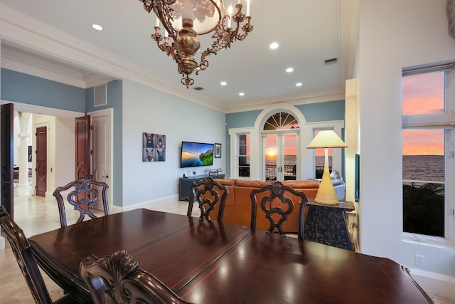 dining room featuring crown molding, french doors, and an inviting chandelier