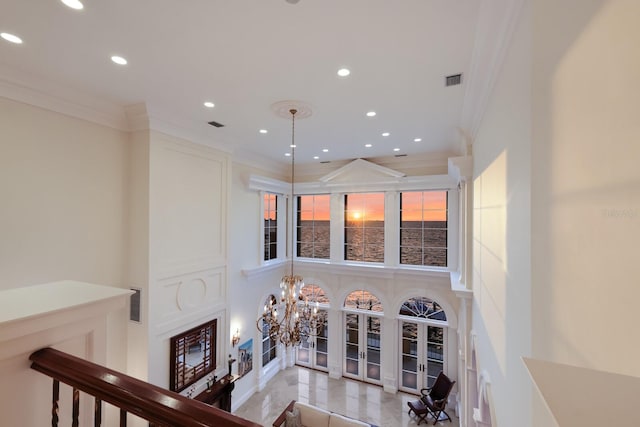 living room featuring french doors, a chandelier, and ornamental molding