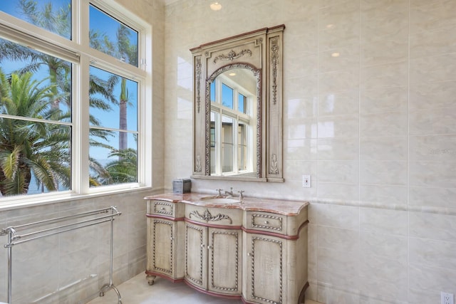 bathroom featuring vanity and tile walls