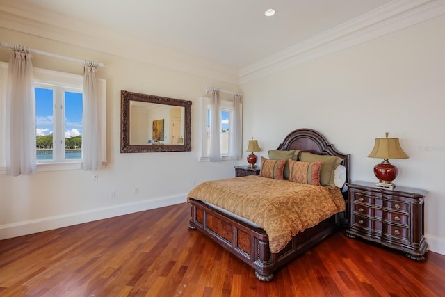 bedroom with dark hardwood / wood-style flooring and crown molding