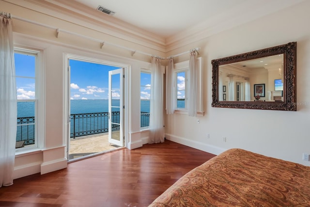 interior space with hardwood / wood-style floors, a water view, access to outside, and multiple windows