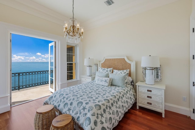 bedroom featuring a water view, dark wood-type flooring, access to outside, and an inviting chandelier