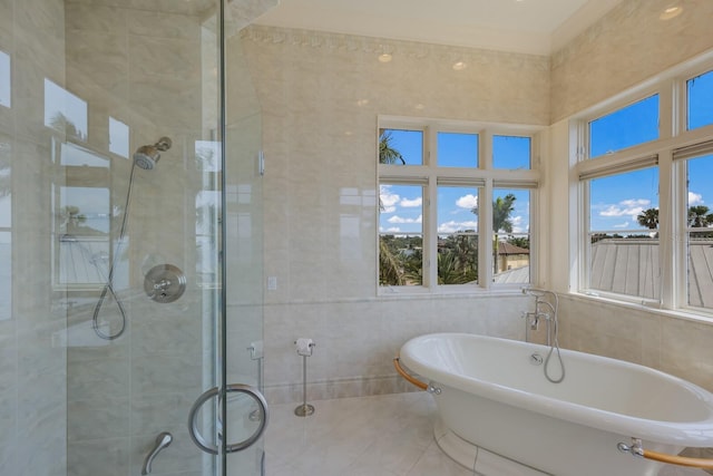 bathroom featuring tile patterned floors, tile walls, and independent shower and bath