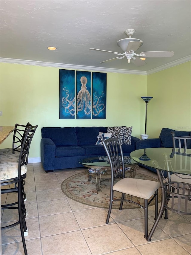 tiled living room with ceiling fan and ornamental molding