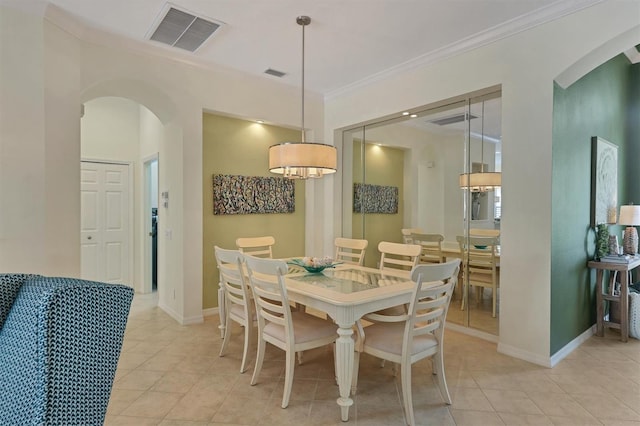 dining area with light tile patterned flooring and ornamental molding