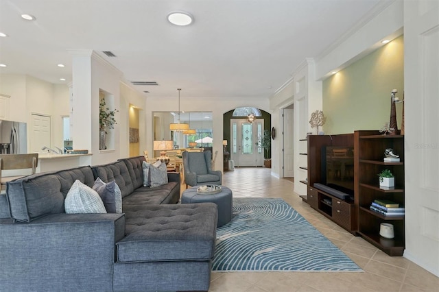 living room with ornamental molding and light tile patterned floors